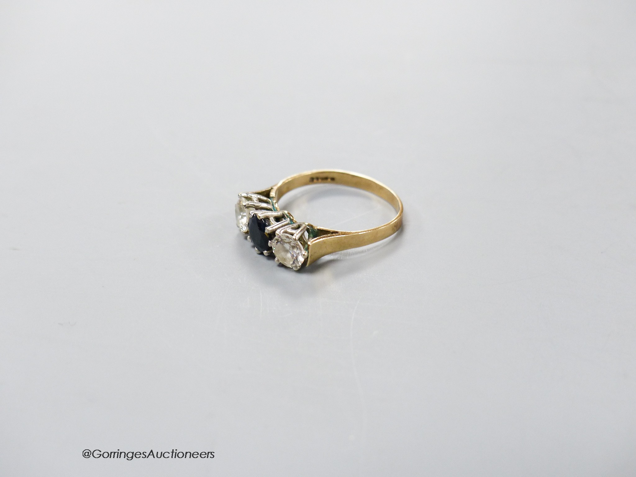 A 9ct gold, sapphire and simulated diamond set three stone ring, size P, gross 2.6 grams.